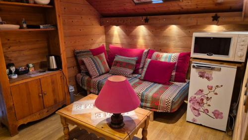 a living room with a couch and a pink lamp on a table at Comme à la maison, chambres au calme in Verrens-Arvey