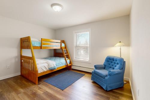 a bedroom with a bunk bed and a blue chair at Peakes Peace - B in Dedham