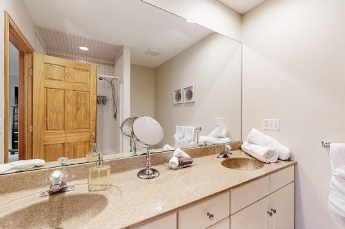 a bathroom with two sinks and a large mirror at Hidden Gem Hideaway in Centerville