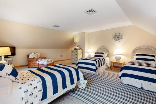een slaapkamer met 2 bedden met blauwe en witte strepen bij Hidden Gem Hideaway in Centerville