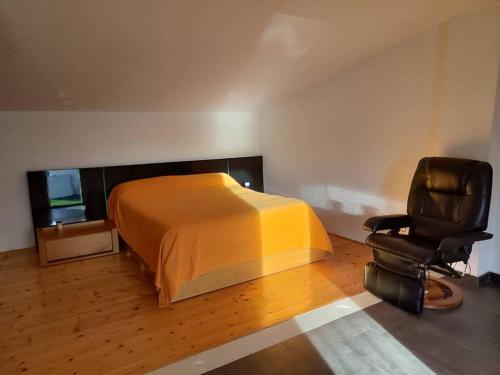 ein Schlafzimmer mit einem Bett und einem Stuhl in der Unterkunft Ca La Perla in Albalat de Taronchers