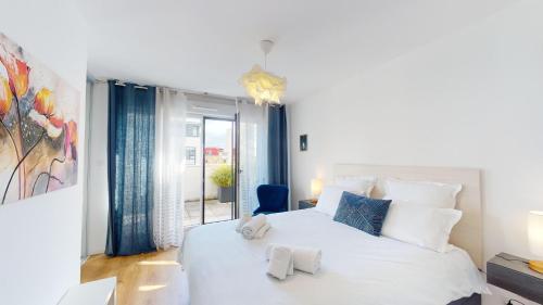 une chambre blanche avec un grand lit blanc et une fenêtre dans l'établissement CityHeart Constellation avec parking, à Strasbourg