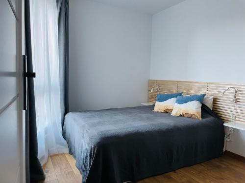 a bedroom with a bed with blue sheets and pillows at Apartament Foka - Rowy in Rowy