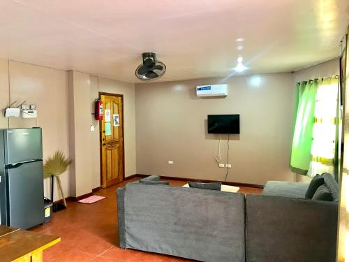 a living room with a couch and a tv at Badladz Staycation Condos in Puerto Galera