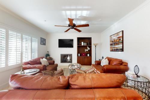 a living room with leather furniture and a ceiling fan at Luxury Golfer's Sanctuary in Indio