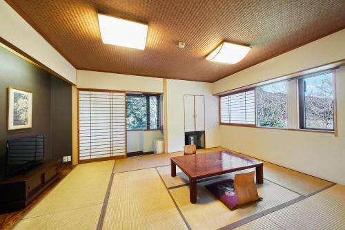 a living room with a table and a tv at Shiki Resort Villa Hakone 80 in Hakone