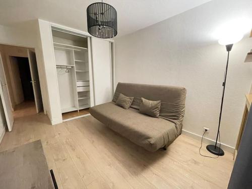 ein Sofa im Wohnzimmer mit Lampe in der Unterkunft Confortable appartement T3 in Saint-Denis