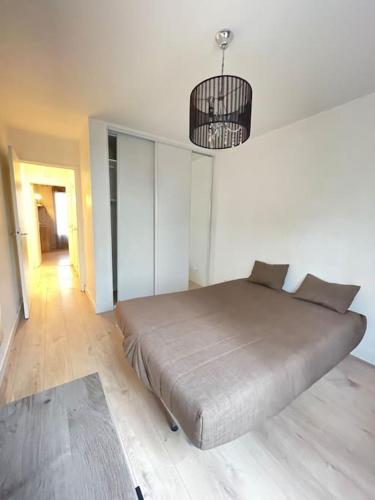 ein Schlafzimmer mit einem großen Bett und einem Kronleuchter in der Unterkunft Confortable appartement T3 in Saint-Denis