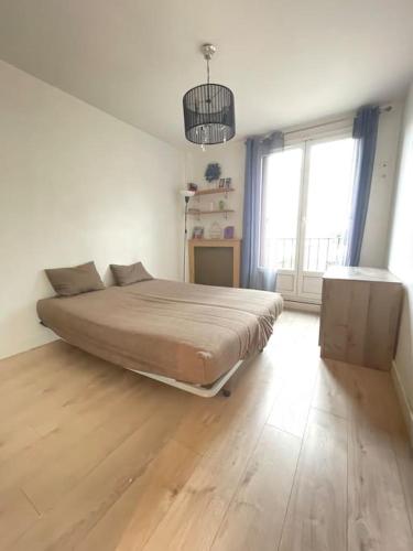 ein Schlafzimmer mit einem Bett und einem großen Fenster in der Unterkunft Confortable appartement T3 in Saint-Denis