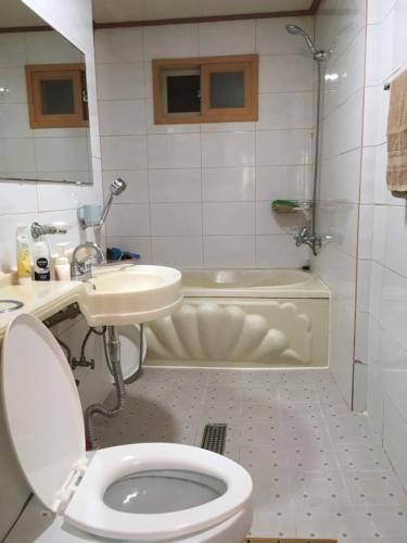 e bagno con servizi igienici, lavandino e vasca. di Harry House a Gyeongju