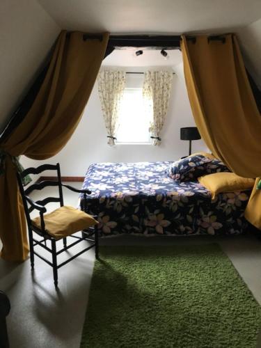 - une chambre avec un lit, une chaise et une fenêtre dans l'établissement Les Dames au chapeau vert, à Saint-Omer