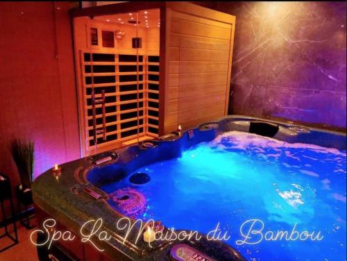 a jacuzzi tub in a room with a building at Loft Spa La Maison du Bambou in Sequedin