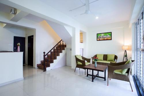 a living room with a couch and chairs and a table at Nature's retreat villa malavli in Pune