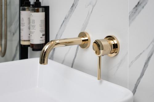 a bathroom sink with a gold faucet at Apartments Wroc'LOVE by me & Mosiężna & Free Garage & Self Check in 24H in Wrocław