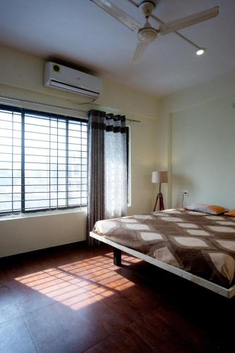 a bedroom with a bed and a large window at Nature's retreat villa malavli in Pune