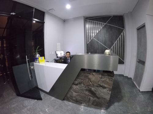 a man sitting at a desk in a room at Penthouses & Suites in Bogotá