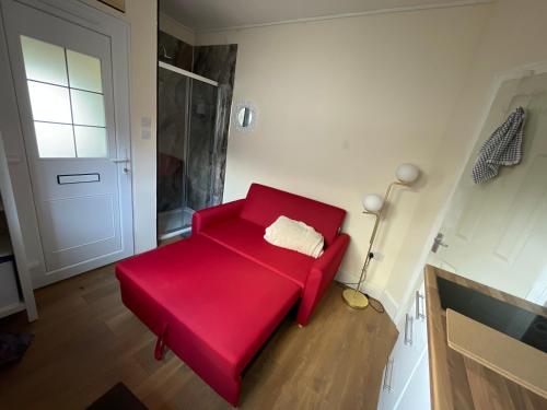 a red couch in a room with a door at Livadia House at St Leonards on Sea in St. Leonards