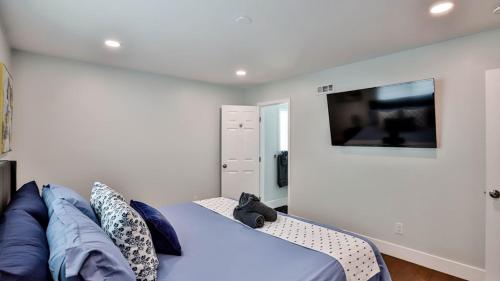 a bedroom with a couch and a flat screen tv at H&H Modern Lux 4BD 1 King Suite 3 Queen SoCal Disney in Westminster
