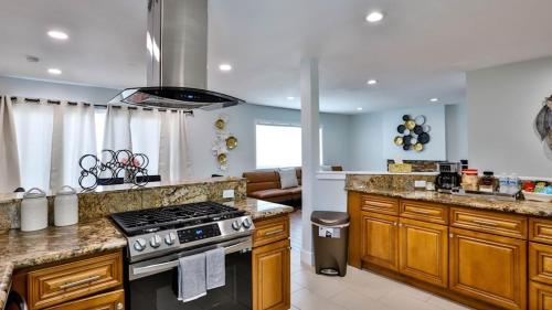 a kitchen with a stove and a counter top at H&H Modern Lux 4BD 1 King Suite 3 Queen SoCal Disney in Westminster