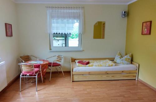 a room with a bed and a table and a window at Ferienwohnung Lindeneck in Neusitz