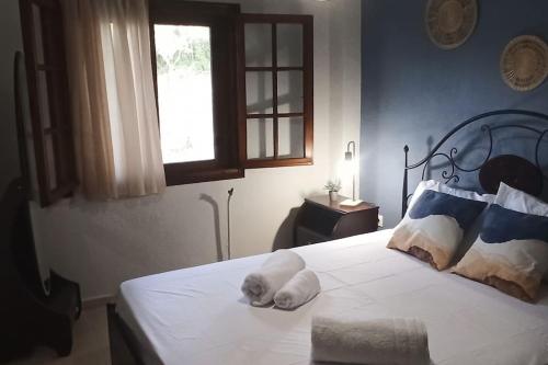 a white dog laying on a bed in a bedroom at Paradise house in Kriopigi