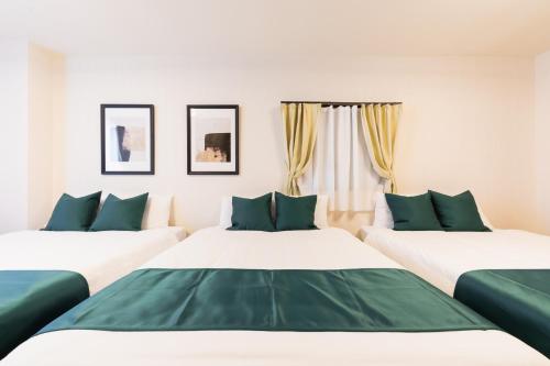 two beds in a room with green and white at soleil Universal Fukushima Noda -vacation rental- in Osaka
