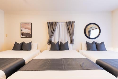 two beds in a room with a window at soleil Universal Fukushima Noda -vacation rental- in Osaka