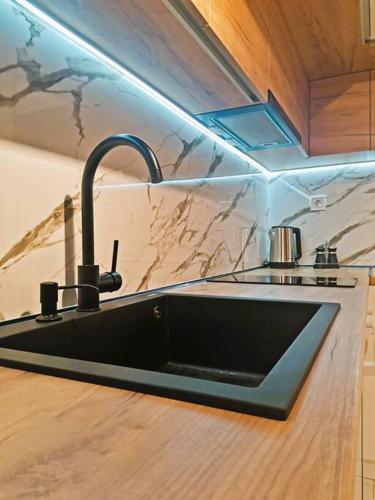 a kitchen sink with a faucet on a counter at Cozy and Stylish Apartament in Stara Zagora