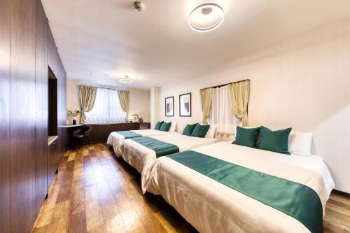 a hotel room with two beds and a desk at soleil Universal Fukushima Noda -vacation rental- in Osaka