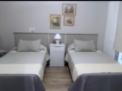 1 dormitorio con 2 camas y mesa con lámpara en Alquiler Temporario -Belgrano C.A.B.A en Buenos Aires