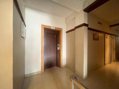 an empty hallway with a door in a building at Rio Rooms Calicut Near Mims Hospital in Kozhikode