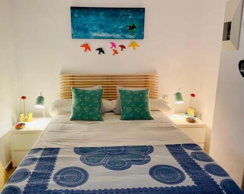 1 dormitorio con 1 cama con almohadas verdes y azules en Estupendo Apartamento Urbanizacion Jardines de Zahara. Zahara de los Atunes, en Zahara de los Atunes