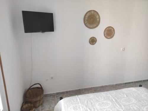a bedroom with a tv on the wall and a bed at Aporthiano Houses in Skala Patmos in Patmos