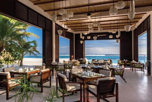 een restaurant op het strand met tafels en stoelen bij OBLU SELECT Sangeli - Premium All Inclusive with Free Transfers in North Male Atoll