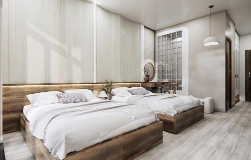 a bedroom with two beds and a desk at T&T Luxury Hotel in Quy Nhon