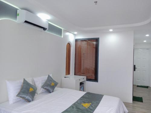 a bedroom with a white bed with two pillows at T&T Luxury Hotel in Quy Nhon