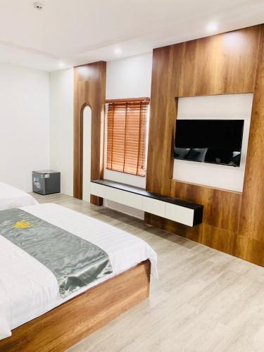 a bedroom with a bed and a tv on a wall at T&T Luxury Hotel in Quy Nhon