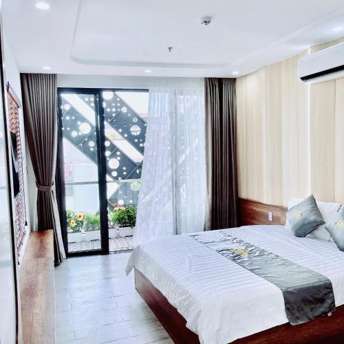 a bedroom with a bed and a large window at T&T Luxury Hotel in Quy Nhon