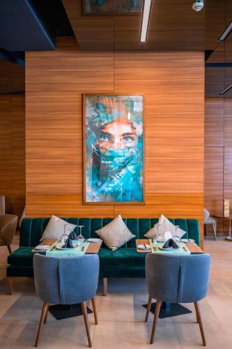 a living room with a green couch and a painting at Kenzi Basma in Casablanca