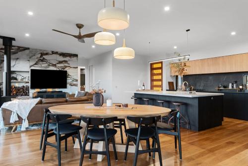 Una cocina y una sala de estar con mesa y sillas. en The Ridge at Maleny 3 Bedroom Deluxe Residence - Panoramic Valley Views, en Maleny