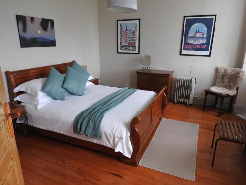 1 dormitorio con 1 cama con sábanas blancas y almohadas azules en Le Petit Couvent, en Musculdy