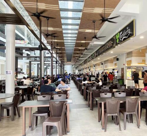 a shopping mall with people sitting at tables at APARTMENTS @ PODIUM, KUCHING in Kuching