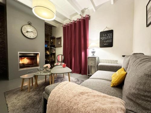 a living room with a couch and a fire place at Maison Kérity with Jacuzzi – Terrace in Paimpol