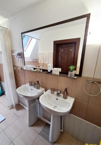a bathroom with two sinks and a large mirror at Cabana Sky High in Ranca