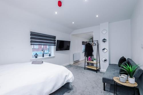 a white bedroom with a bed and a window at Modern Studio Hindley in Hindley