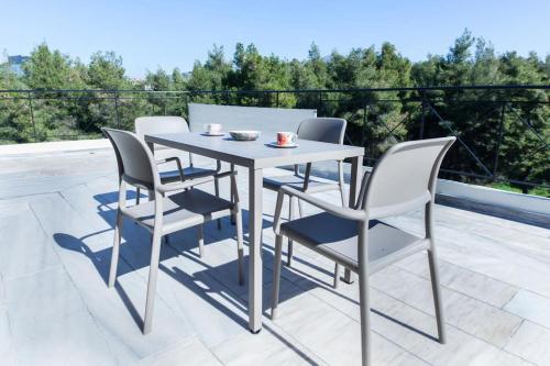 un patio con mesa y 4 sillas en Marousi Modern Green Oasis Apt w Amazing Balcony en Athens