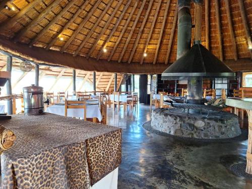 a restaurant with a fireplace in the middle of a room at Hawane Resort in Mbabane