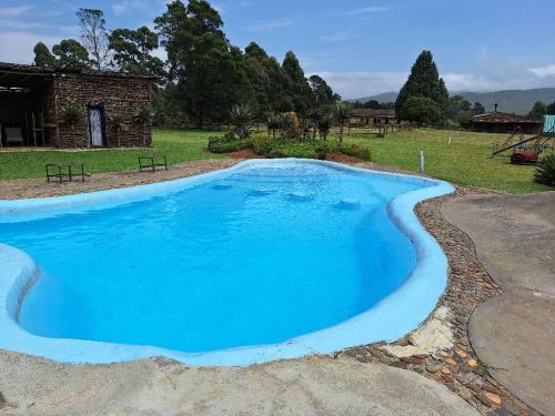 a large blue swimming pool in a yard at Hawane Resort in Mbabane