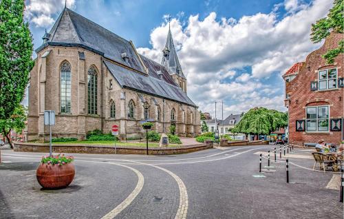 a large stone church with a vase on the street at Kruudhuuske in Aalten