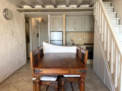 cocina con mesa de madera en una habitación en Punta Est Trilocale Splendida Vista Mare, en Capo Coda Cavallo